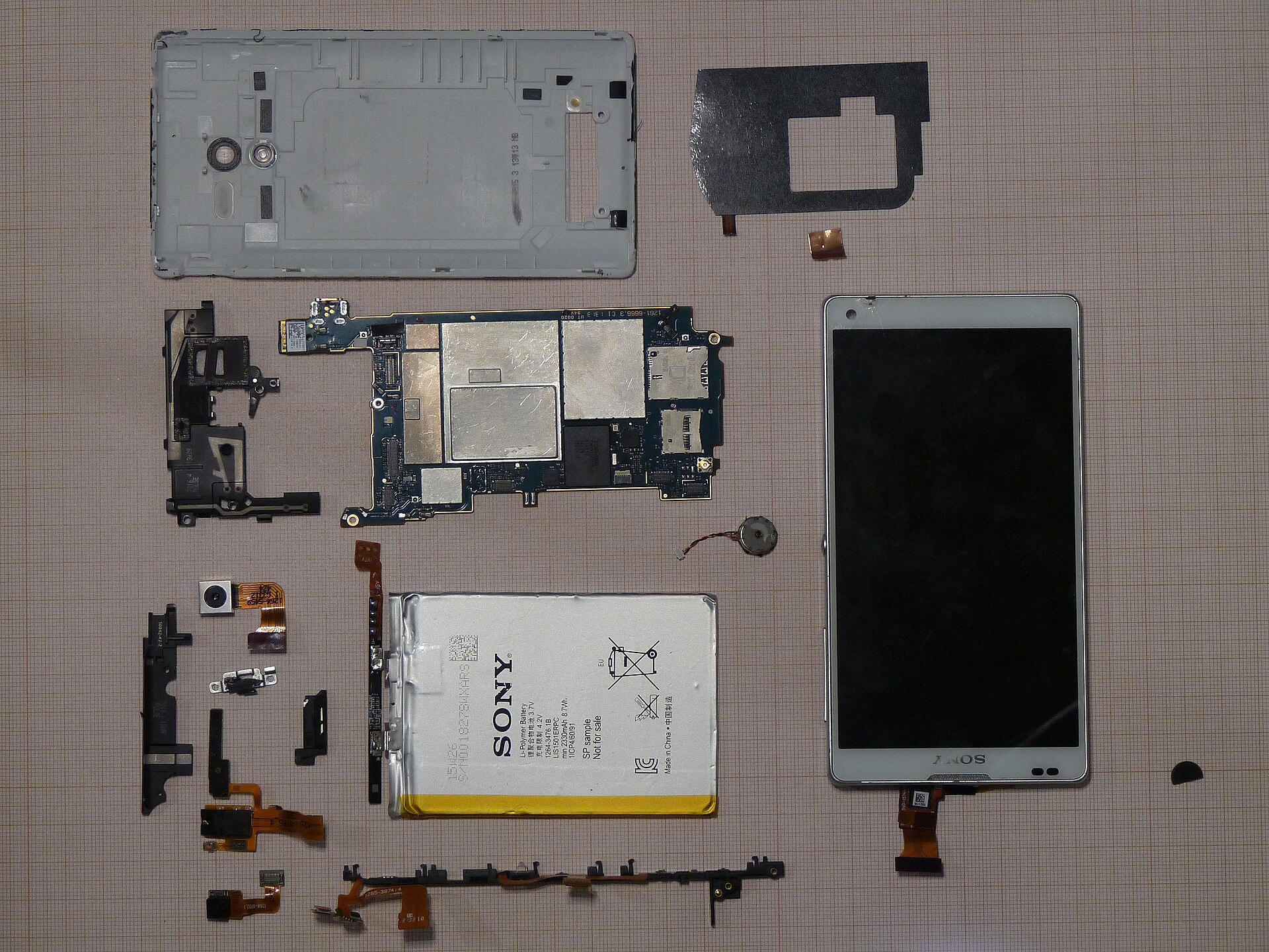 Disassembled smartphone showing internal hardware and battery